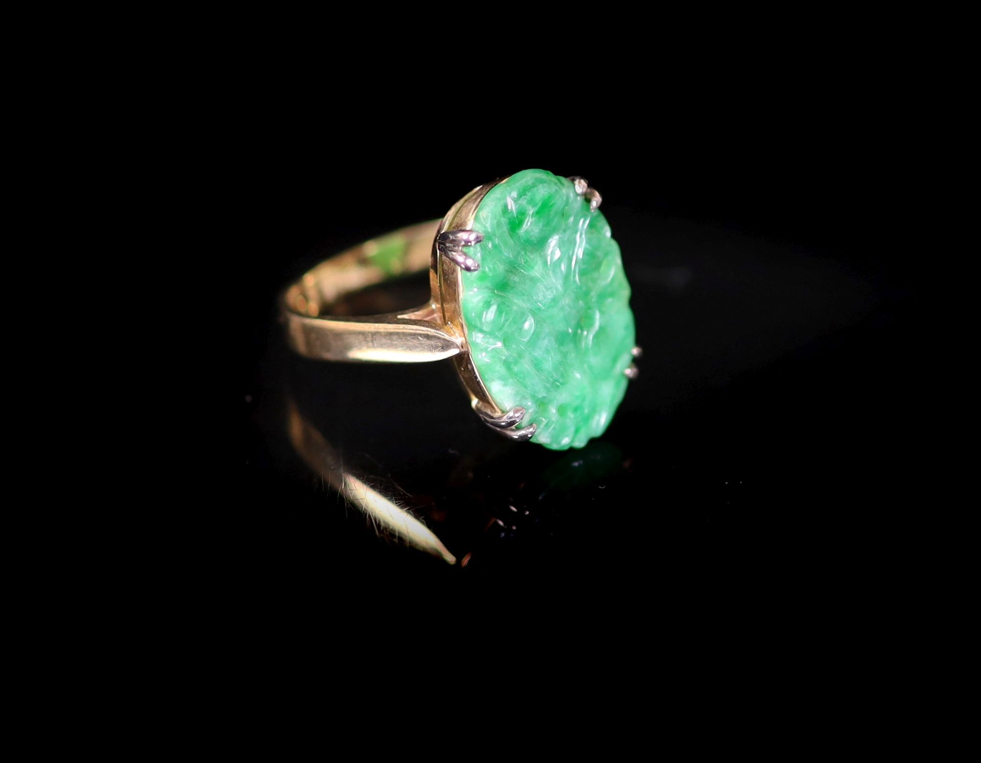 A mid 20th century gold and carved oval jade set dress ring
